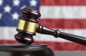 Close up of wooden judge gavel. American flag in background